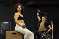 Woman in Black Sports Bra and White Pants Sitting on Brown Wooden Seat