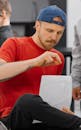 A Man in Red Shirt Holding a White Paper