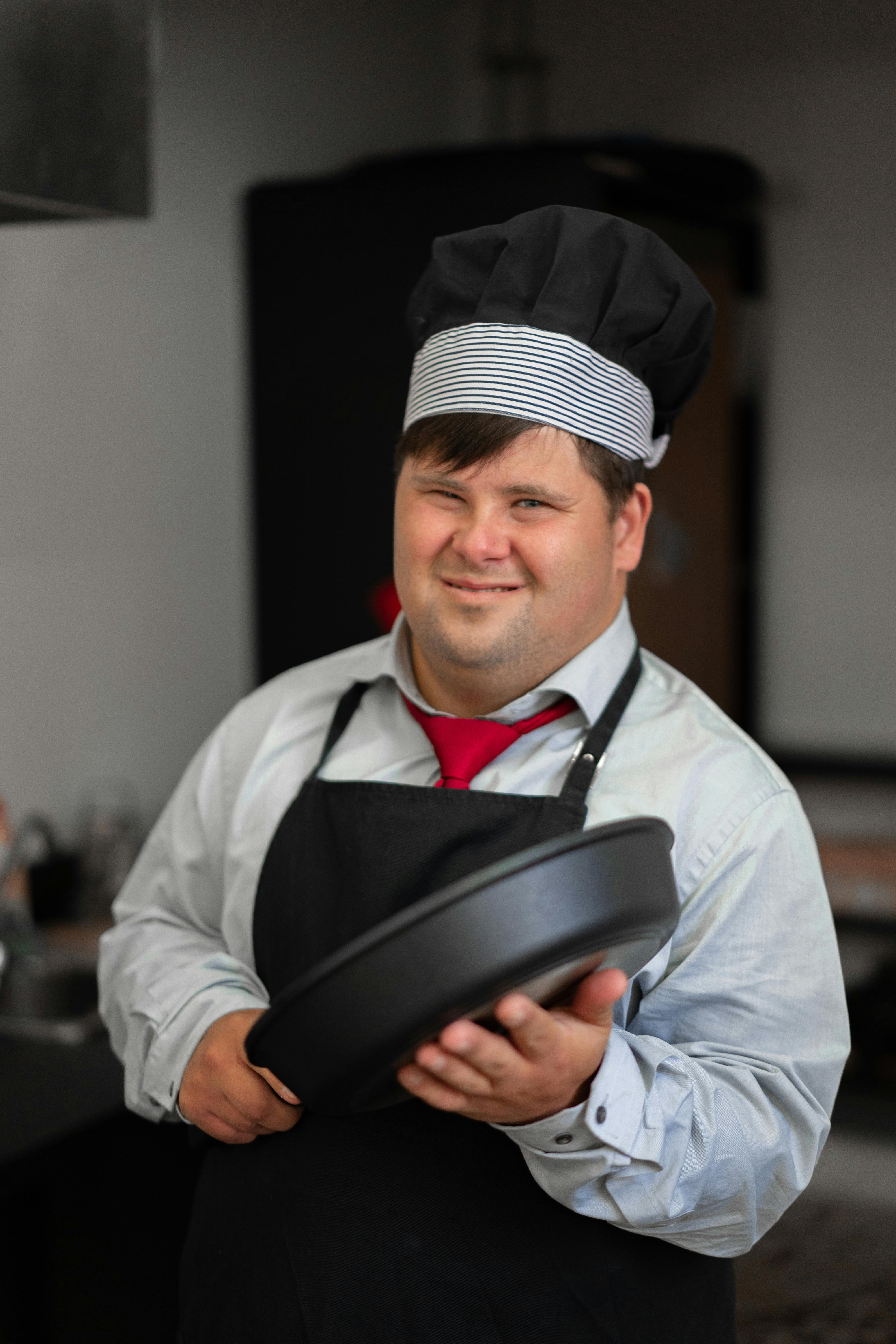 a man in long sleeves and apron is holding a pot