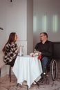 Man in Black Sweater Sitting Beside Woman in White and Black Stripe Long Sleeve Dress