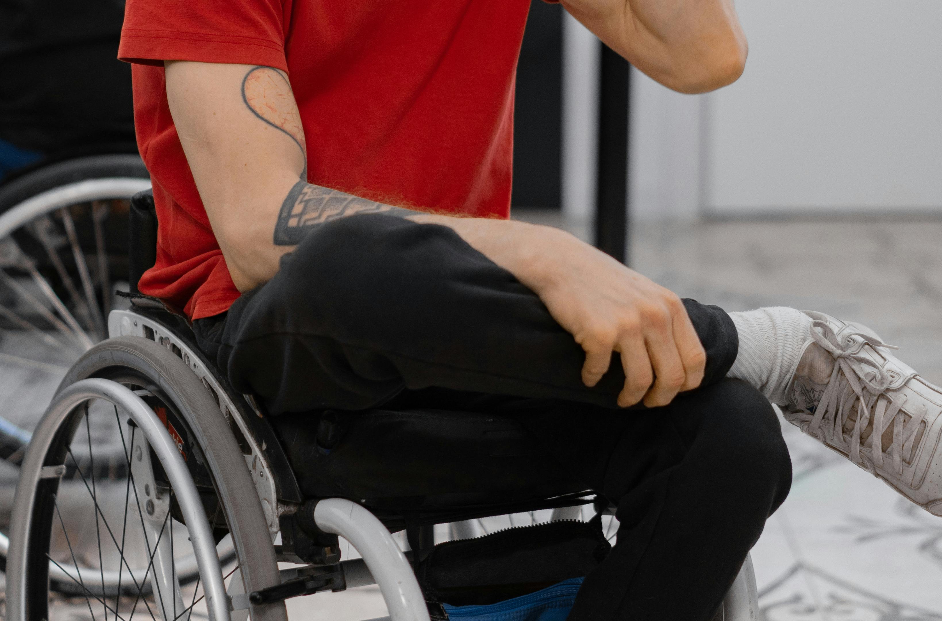 A person positioned in a wheelchair with supportive cushioning