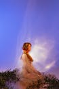 Woman in White Dress Standing on Green Grass Under Blue Sky