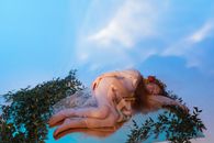 Woman in White Dress Lying on Green Grass
