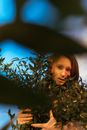 Woman in Black Hat Standing Beside Green Plant