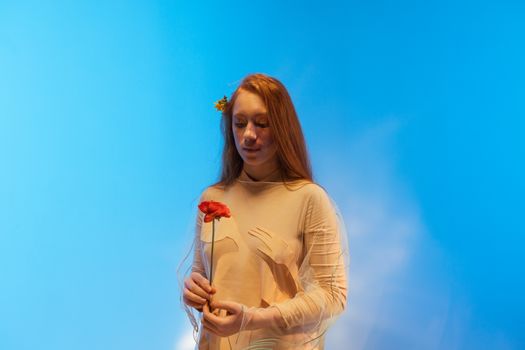 A Pretty Woman in Beige Dress Holding a Flower
