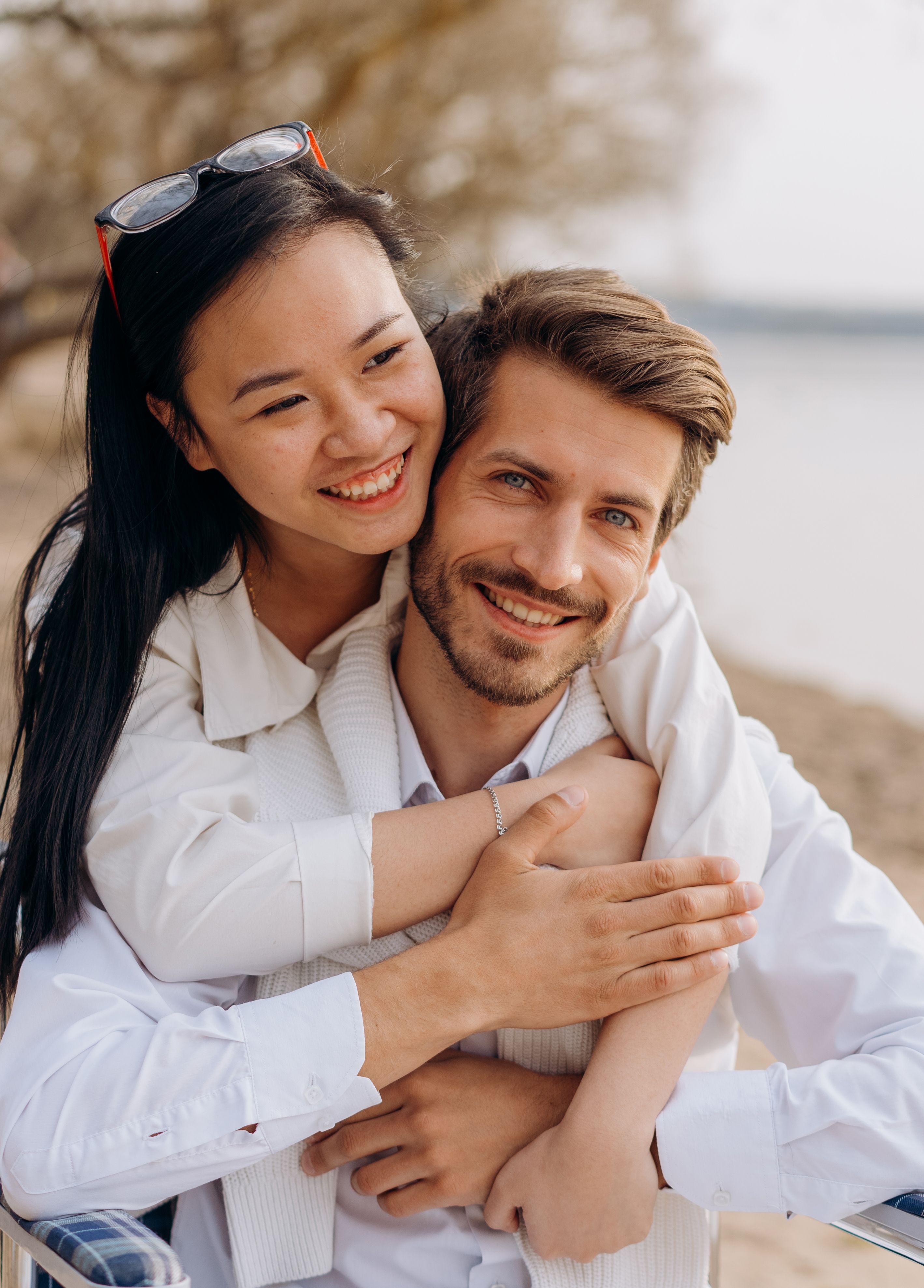 Happy couple embracing on a sandy beach, showcasing love and happiness.