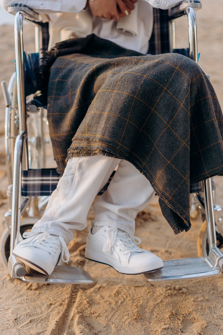 Person In White Pants And White Sneakers Sitting On The Wheelchair 