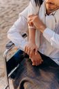 Person in White Dress Shirt and Black and Gray Plaid Skirt Sitting on Stainless Steel Chair
