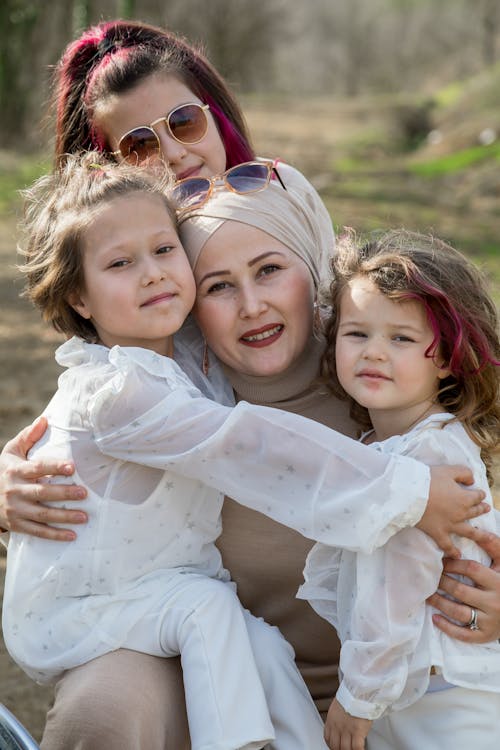 Cheerful woman in headscarf with happy daughters