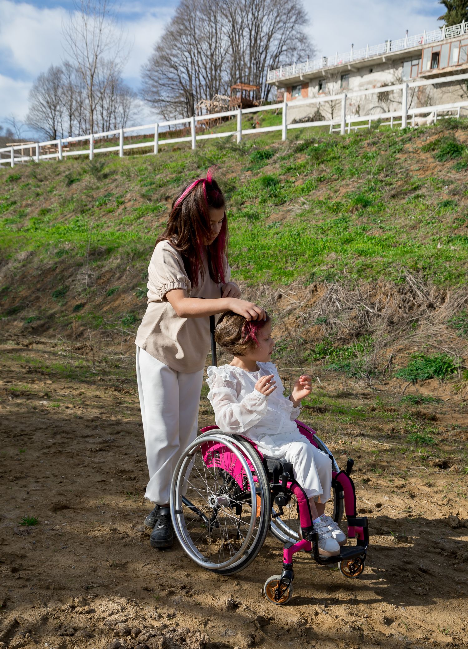 Teenage caregiver supporting a younger child using a wheelchair