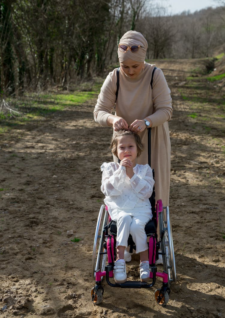 Mother With Daughter In Wheelchair On Path