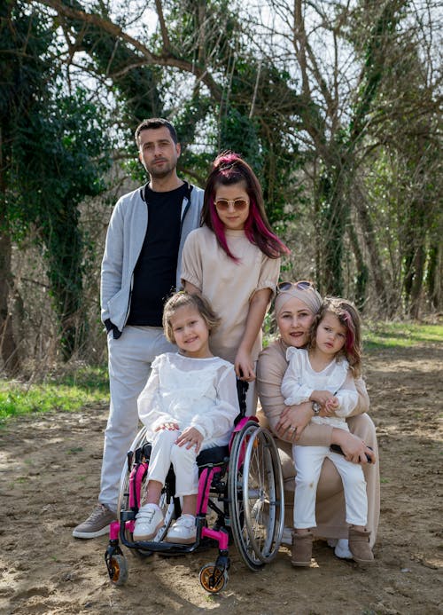 Free Happy family with girl in wheelchair in park Stock Photo
