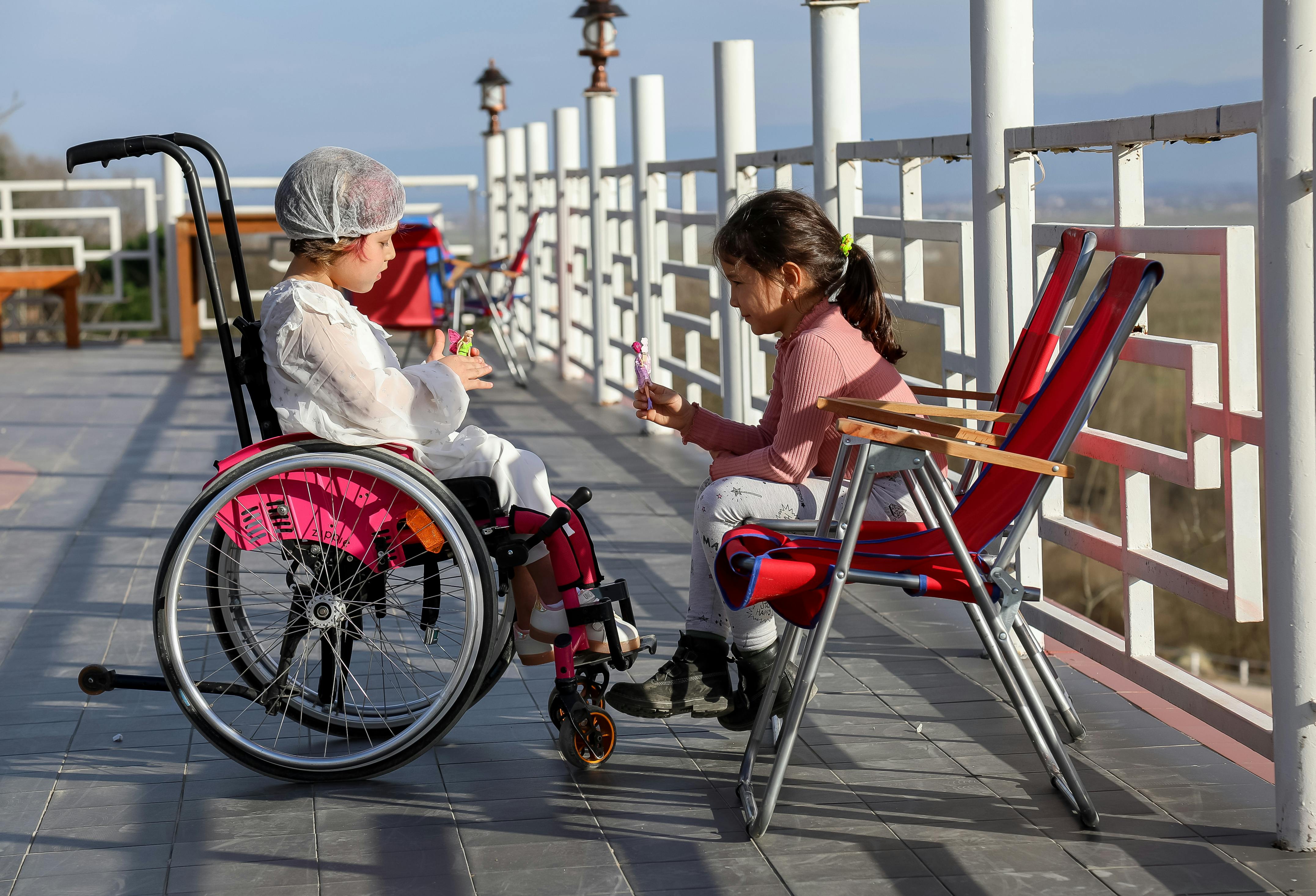 girl in wheelchair talking with friend