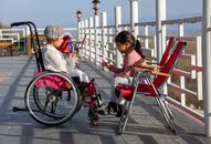 Girl in wheelchair talking with friend