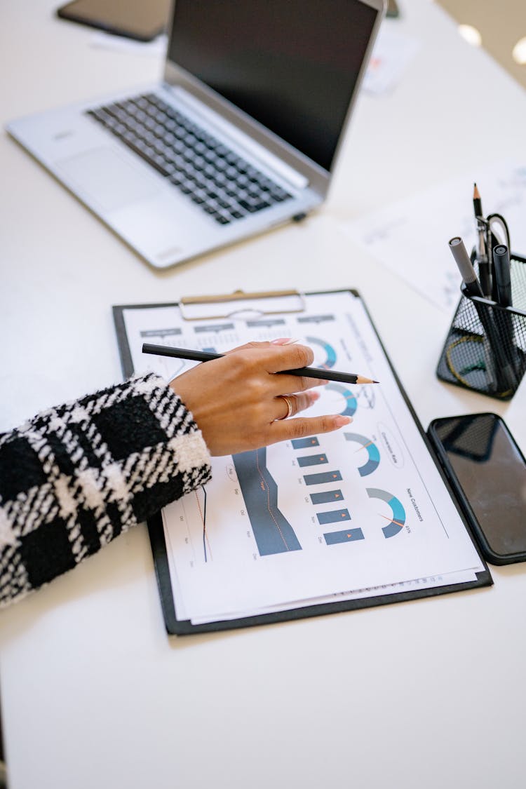 Woman Holding Hand On Papers With Business Analysis