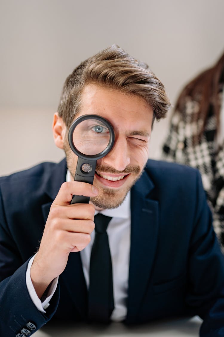 Man In Blue Suit Holding Magnifying Glass