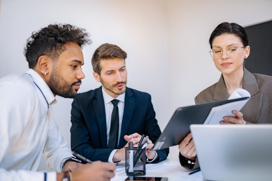 Free Coworkers Looking at a Document in a Meeting Stock Photo