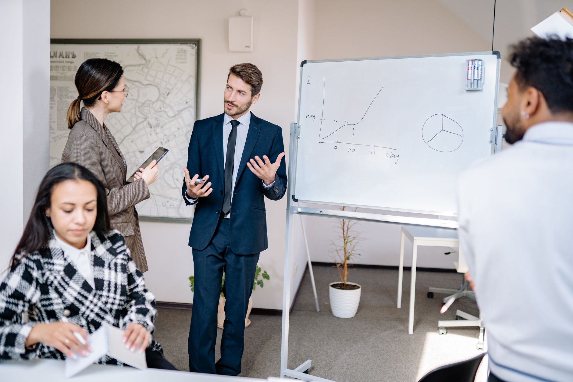 Business team discussing strategies at a whiteboard in a contemporary office setting.