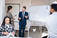 Man in Black Suit Jacket Standing Beside Woman in Black and White Checkered Dress Shirt