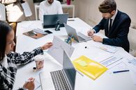Man in Black and White Long Sleeve Shirt Using Macbook Pro