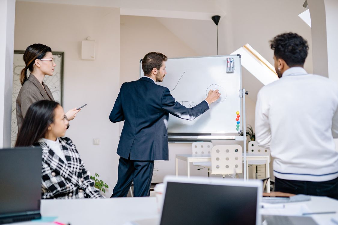 A small team gathered around a whiteboard during a planning session