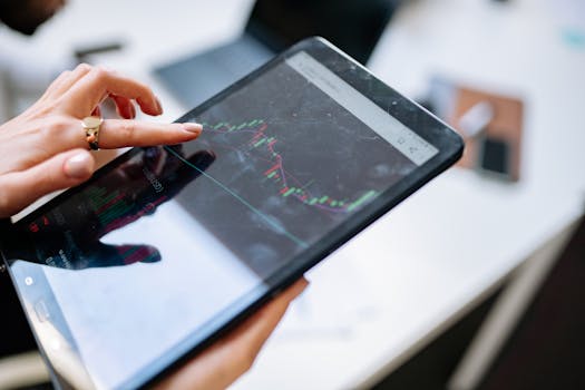 Close-up of a woman using a tablet to analyze stock market graphs.