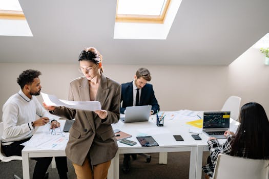 Group of colleagues working together with laptops and documents in a bright office.