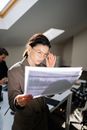 Woman Holding Her Eyeglasses While Looking at the Papers