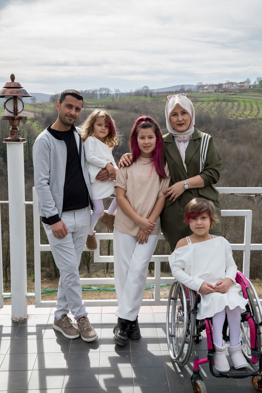 Diverse family with grandmother and children including girl in wheelchair enjoying time together in park