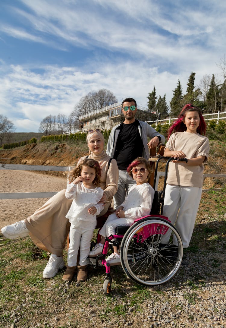 Loving Cheerful Family With Cute Daughter And Girl In Wheelchair