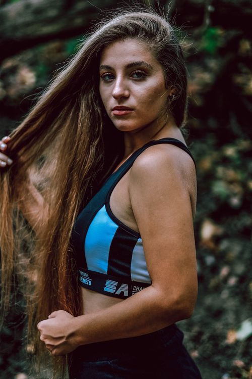 Free Portrait of a woman in sportswear standing outdoors with long hair, displaying confidence. Stock Photo