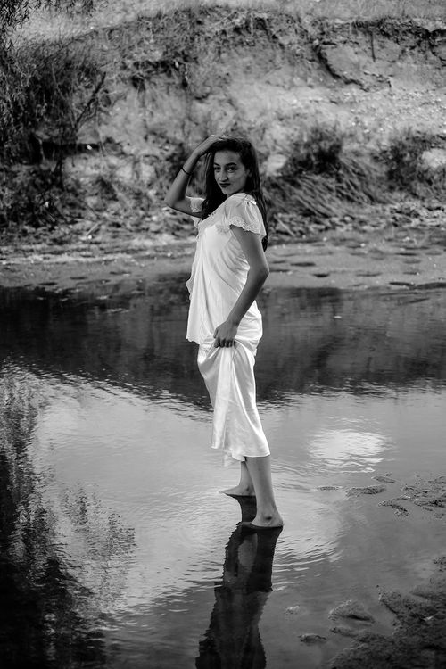 Free Black and white portrait of a woman standing in a river, classic and timeless. Stock Photo