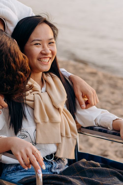 Free A happy woman in a wheelchair enjoying a day by the beach, radiating joy and warmth. Stock Photo