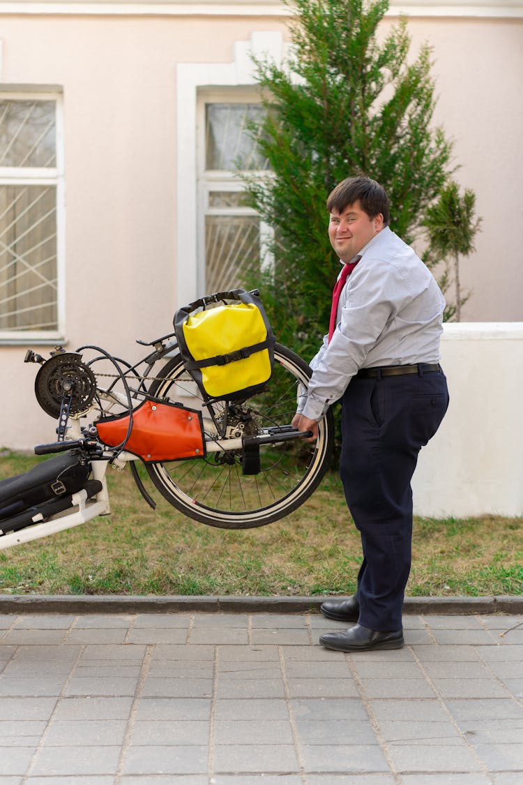 A Man Carrying The Wheel Of A Bicycle