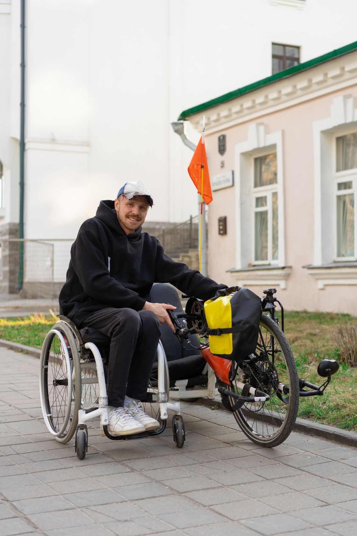 Smiling rider with adaptive mobility equipment and a bicycle outdoors