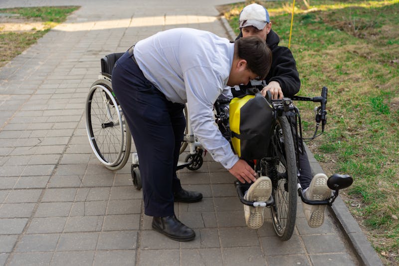 Support worker helping a man navigate outdoors in an electric wheelchair