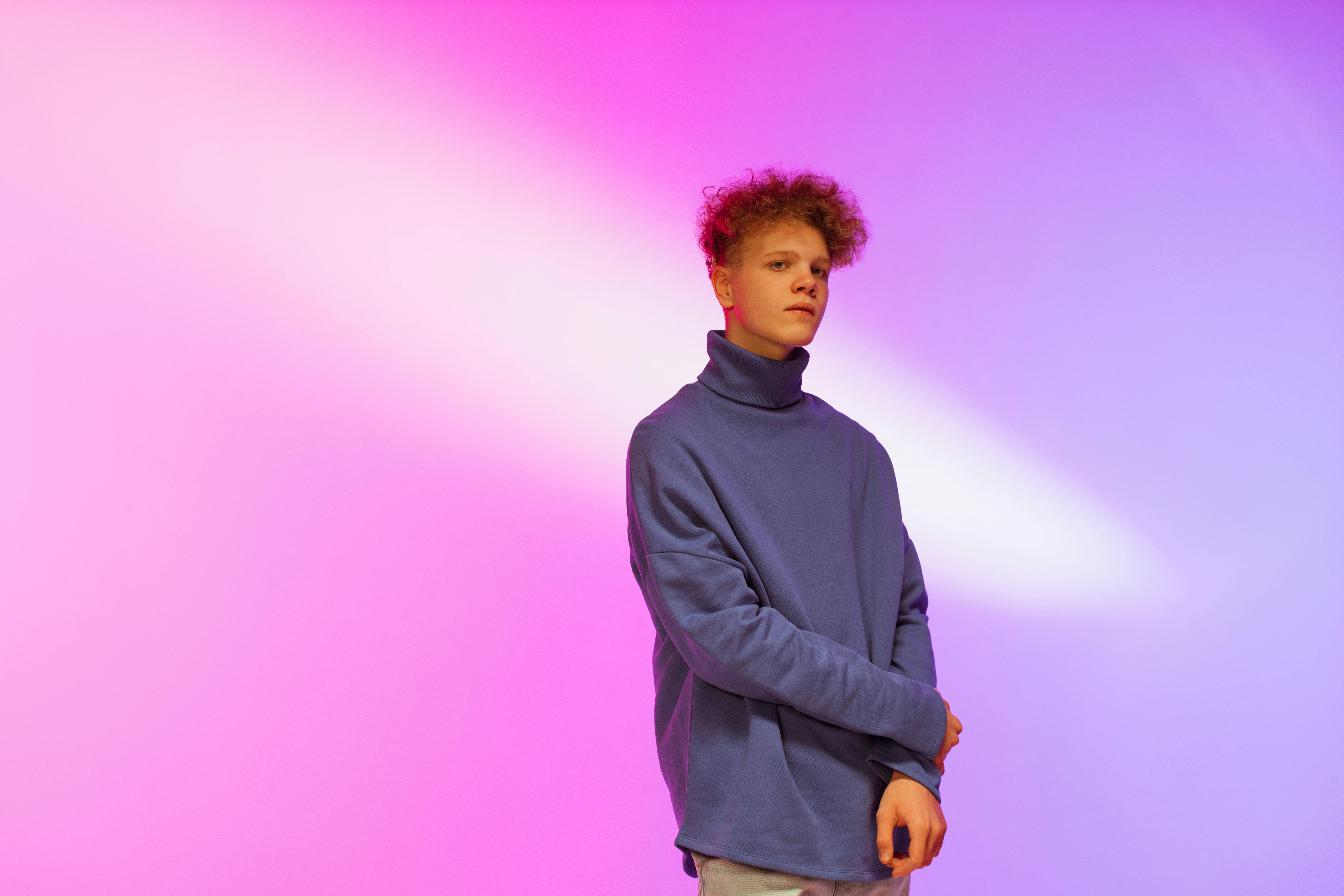 curly haired boy wearing blue turtleneck sweater