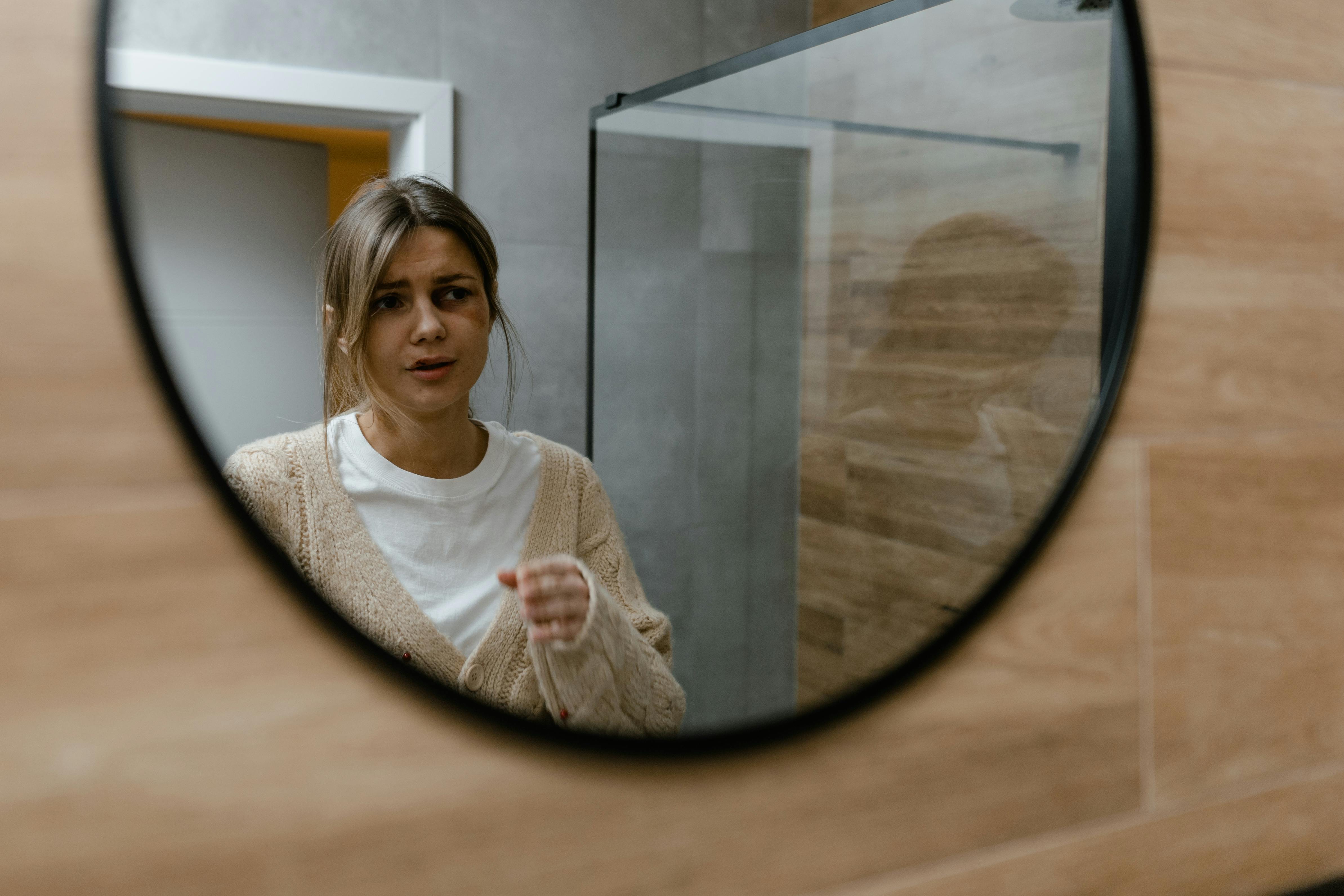 a woman with a black eye looking at a mirror