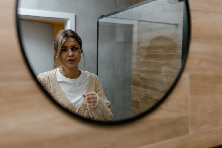 A Woman With A Black Eye Looking At A Mirror