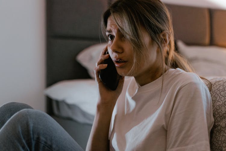 A Woman In White Shirt Calling On Her Cellphone