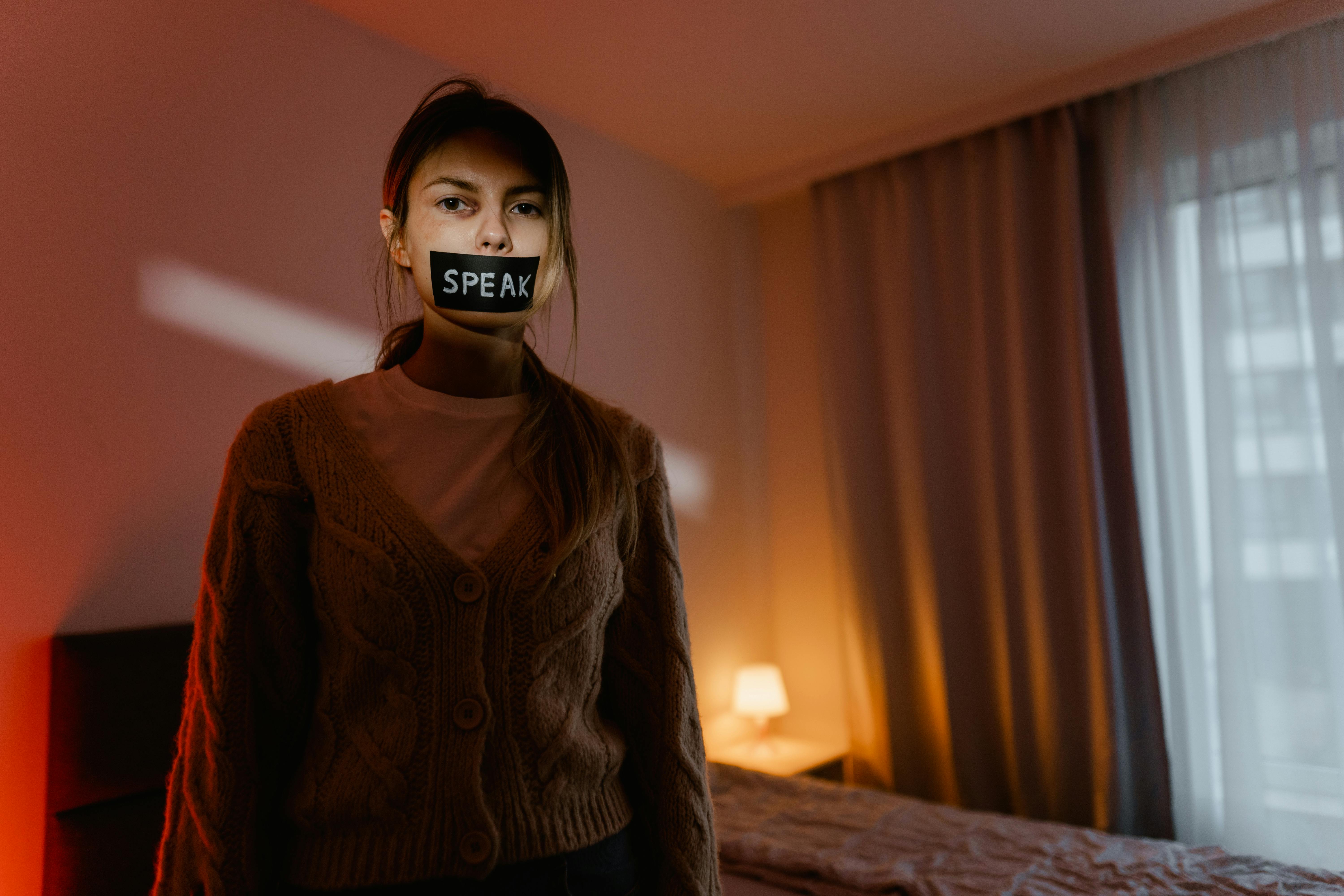 a woman with black tape on her mouth looking at the camera