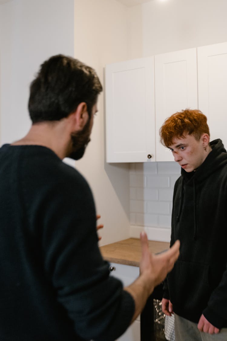 Two Men In Black Shirts Talking