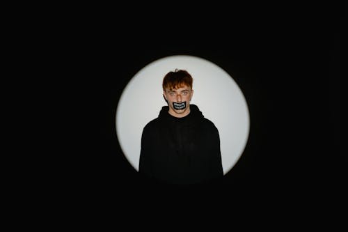 Free Assaulted Man in Black Sweater with Tape on Mouth Stock Photo