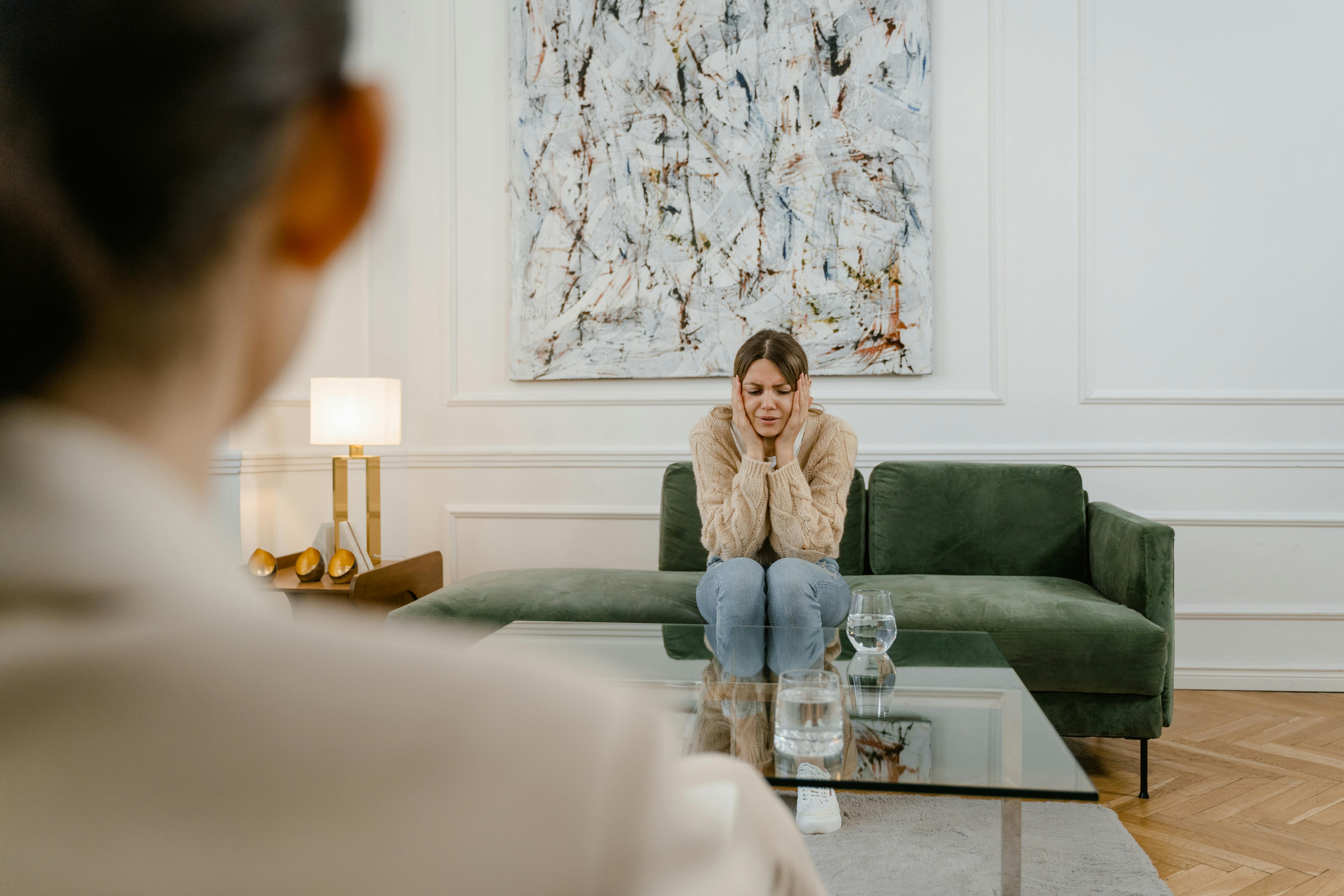 a sad woman sitting on a sofa