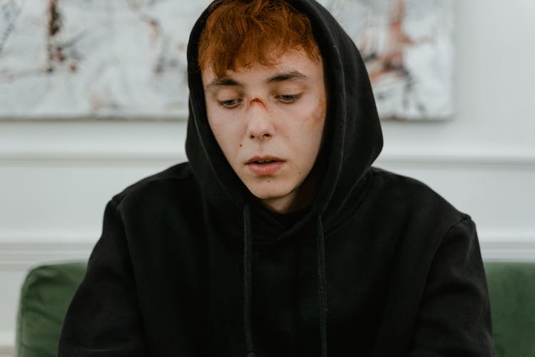 A Man In Black Hoodie Sitting On The Couch