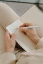 Close-Up Shot of a Person Writing on Notebook