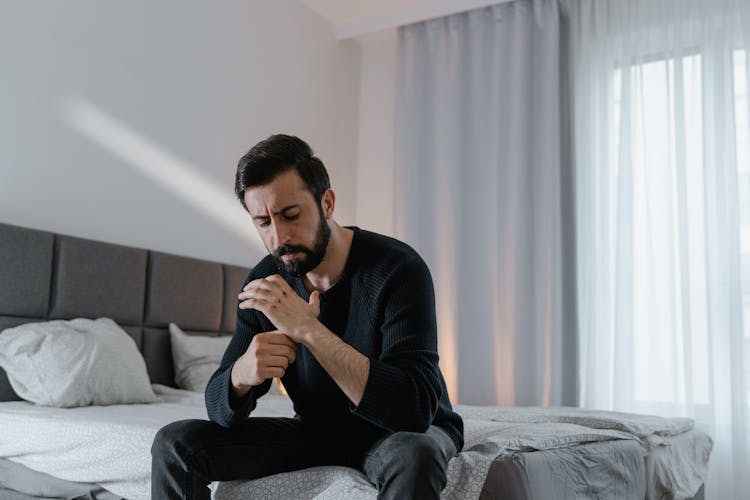 A Man Sitting On A Bed