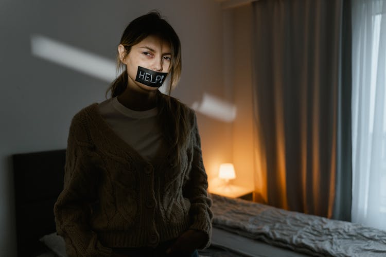 A Woman With Tape On Her Mouth