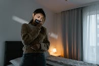 Woman in Brown Sweater Holding Black Ceramic Mug