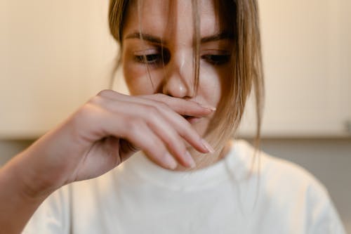 Free Woman in White Shirt with Hand Over Lips
 Stock Photo